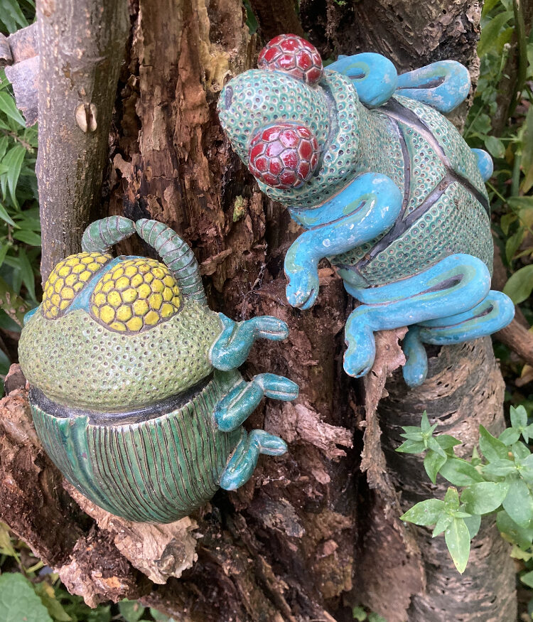 Conceptual ceramic interpretations of wood boring beetles against the backdrop of a decaying beetle inhabited cherry tree stump.
